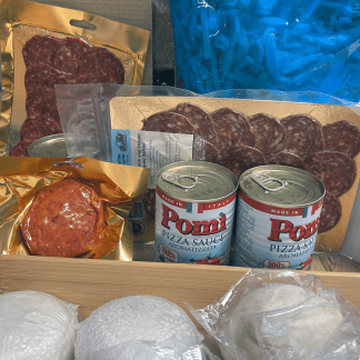 A kit of pizza ingredients, including dough balls, tomato pizza sauce, grated mozzarella, pepperoni, salami and nduja